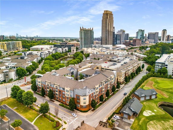 Aerial view of a cityscape with various buildings and green areas.