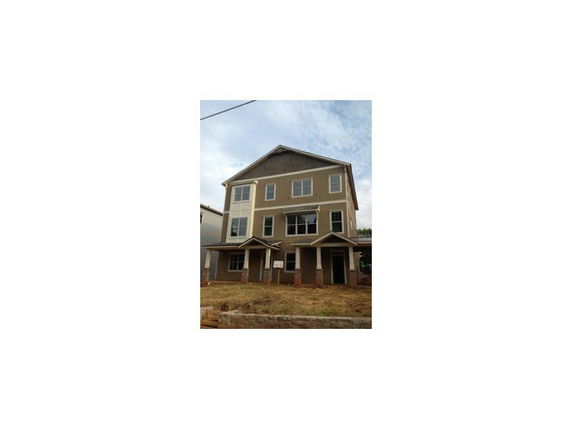Front view of a three-story house with a gabled roof and multiple windows.