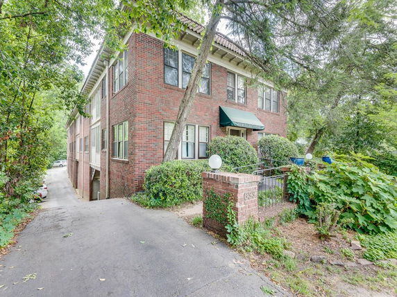Front view of a two-story brick house with a green awning.