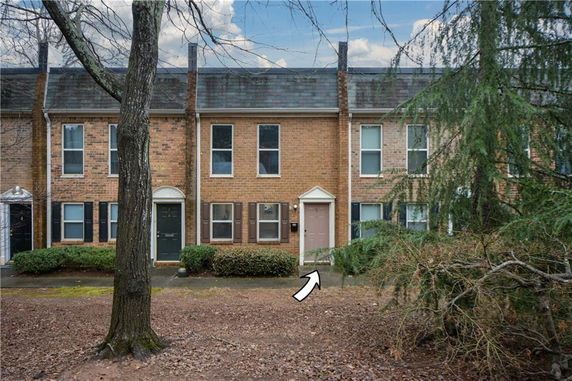 Front view of a townhouse with a brick facade and a main entrance door.
