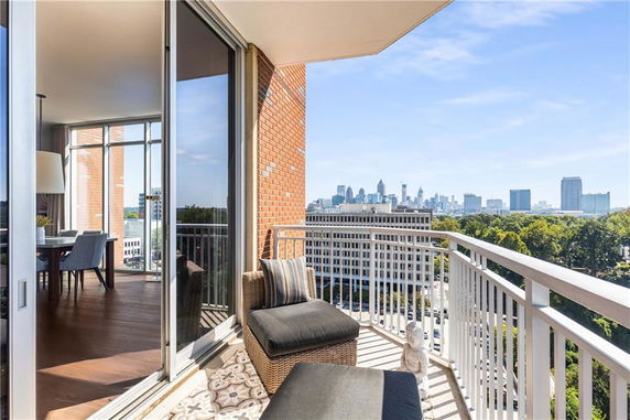 View from a balcony overlooking a city skyline and greenery.