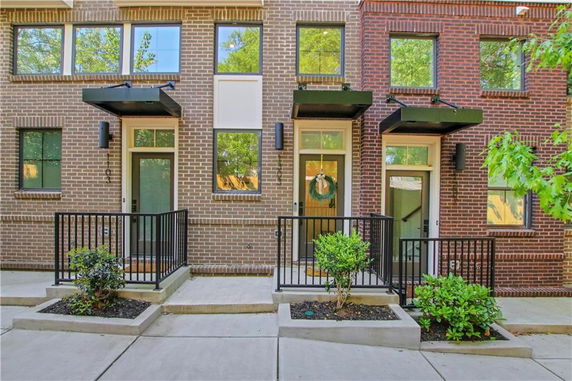Front view of a brick townhouse with two entrances and small porches.