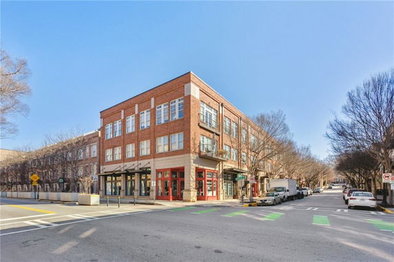 Front view of a multi-story brick building on a street corner.