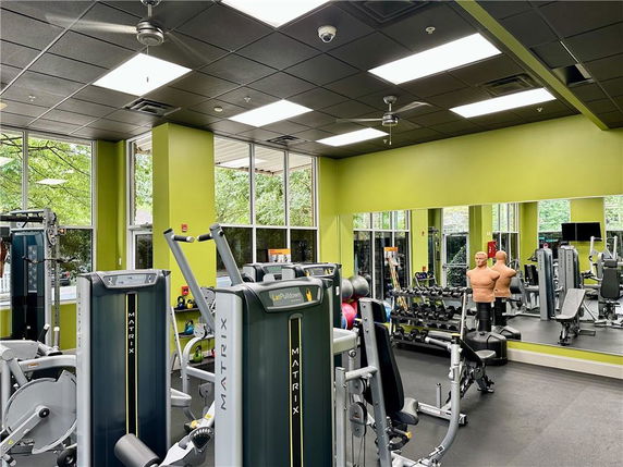 Indoor gym area with exercise machines and equipment.