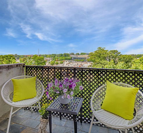 Outdoor balcony with chairs and a view of the surrounding area.