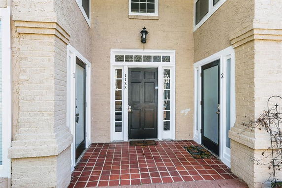 Front view of a house entrance with double side doors and a central main door.