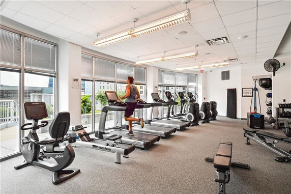 Room with fitness equipment including treadmills and exercise bikes.