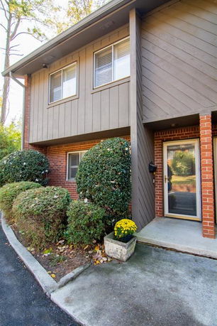 Front view of a two-story house with brick and wood paneling.