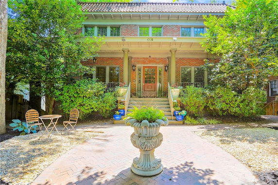 Front view of a two-story house with a porch and columns.