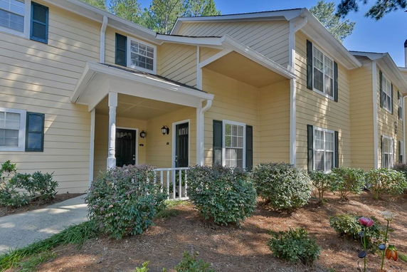 Front view of a two-story house with beige siding and white trim.