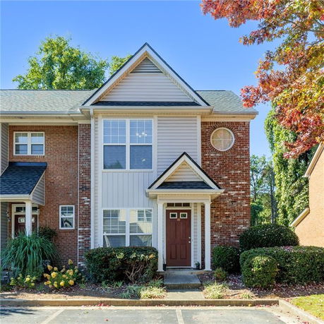 Front view of a two-story townhouse with brick and siding exterior.