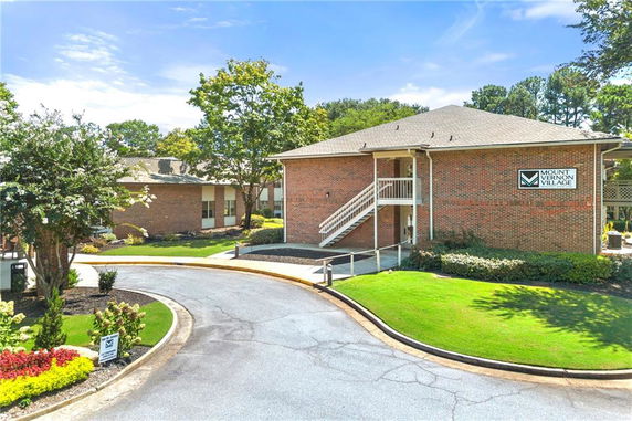 Front view of a two-story brick building with a staircase leading to the upper floor.