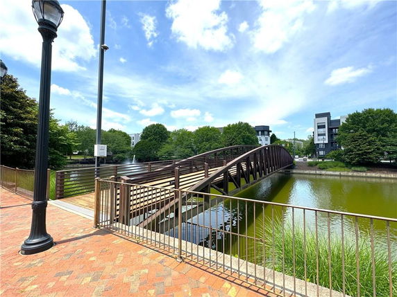 A bridge over a body of water with buildings and trees in the background.
