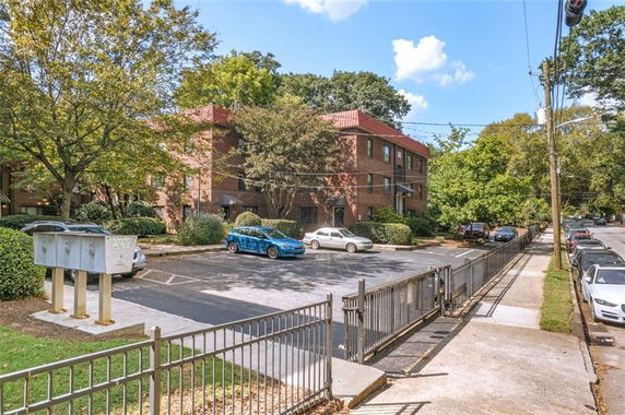 Outdoor parking area in front of a brick building.