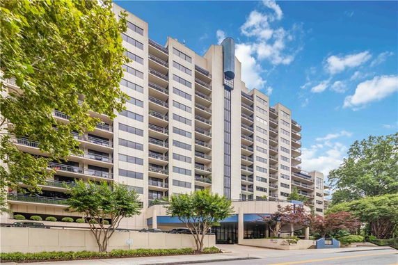 Front view of a multi-story apartment building with balconies.