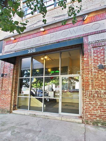 Front view of a brick building with large glass doors and windows.