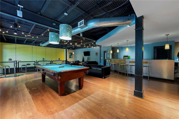 Indoor area with billiards table, sofas, and bar seating for recreation.