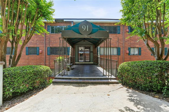 Front view of a two-story brick building with an entrance canopy.