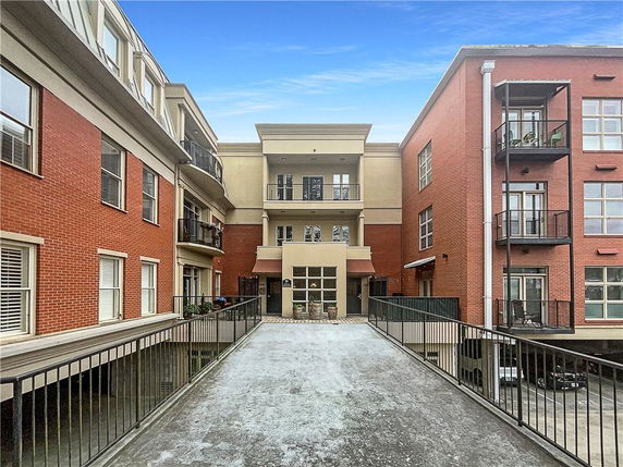 Front view of a multi-story building complex with balconies and red brick exterior.