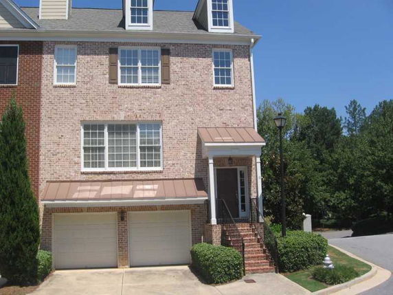Front view of a multi-story townhouse with a double garage.