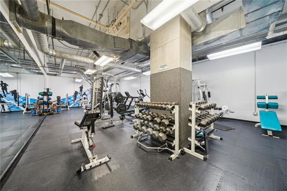 Indoor gym area with weights and exercise equipment.