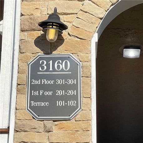 Exterior view with a sign displaying building number and floor information.