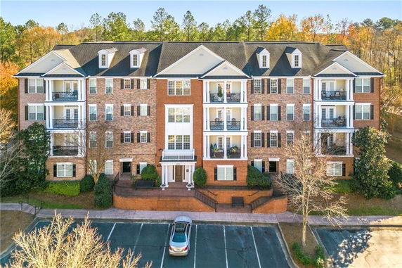 Front view of a multi-story brick building with balconies and dormer windows.