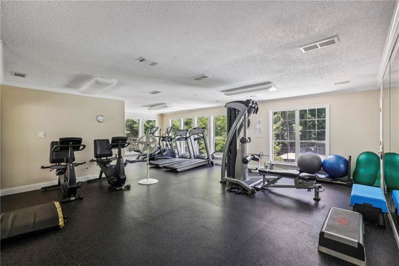 Interior view of a gym with exercise equipment and large windows.