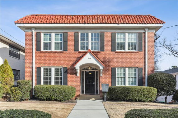 Front view of a two-story brick house with a red tiled roof.