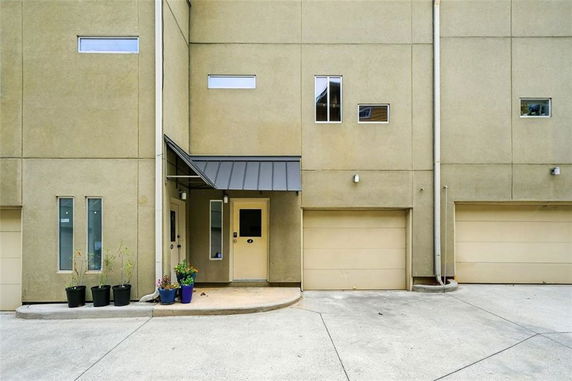 Front view of a house with a garage and a covered entryway.