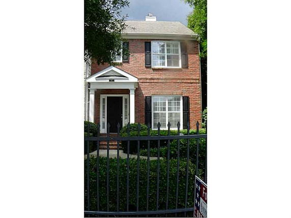 Front view of a two-story brick house with a gabled entryway.
