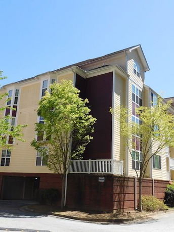 Front view of a multi-story residential building with large windows and a prominent corner design.