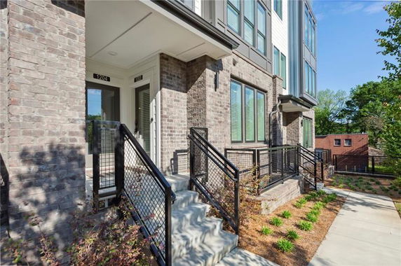 Front view of a modern multi-story brick building with steps leading to the entrance.
