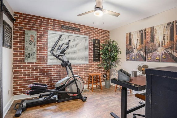 Room with exercise equipment and brick walls