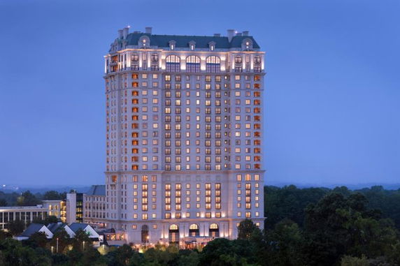 Front view of a tall, illuminated multi-story building.