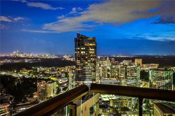 Panoramic cityscape view at night from a high vantage point.