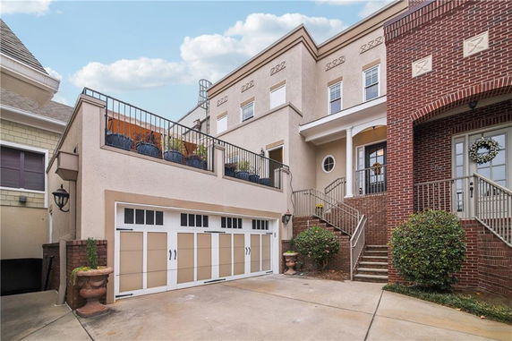 Front view of a multi-story house with a garage and brick facade.