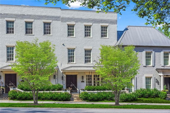 Front view of a three-story townhouse with brick exterior and multiple windows.