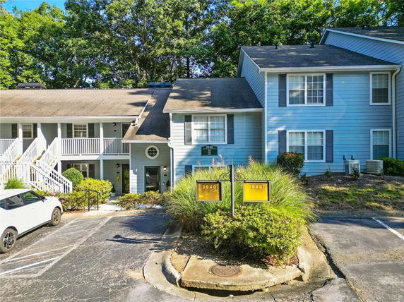 Front view of a two-story residential building with light blue siding and a gable roof.