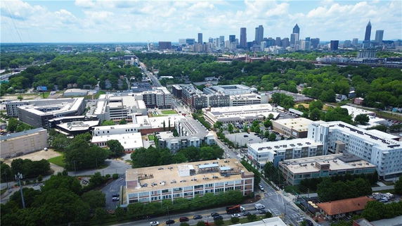 Panoramic view of a cityscape with buildings and green areas.
