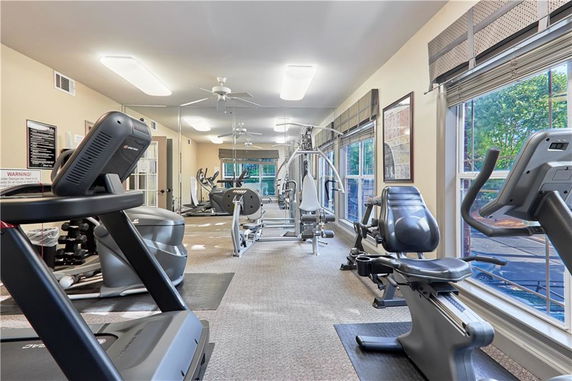 Room equipped with various gym equipment including treadmills, weight machines, and exercise bikes.