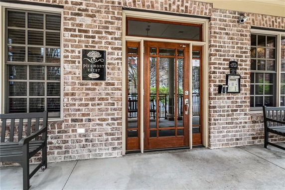 Front entrance of a building with brick walls and glass doors.