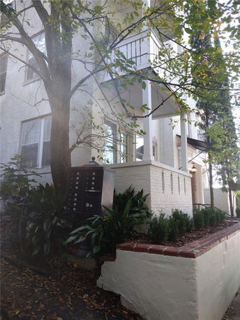 Front view of a multi-story brick building with a balcony.