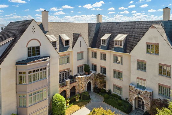 Front view of a multi-story building with steep roofs and multiple dormer windows.