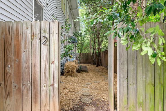 Side view of a house with a wooden fence and garden path.