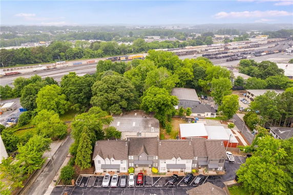 Panoramic view of residential buildings and surrounding area with trees and railway tracks.