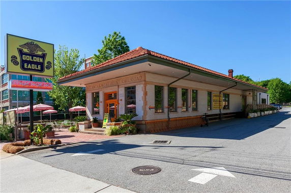 Front view of a building with a sign reading Golden Eagle and patio seating area.