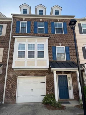 Front view of a three-story townhouse with brick facade and blue shutters.