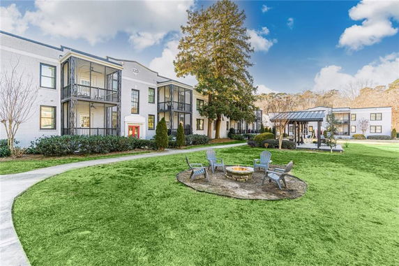 Front view of a two-story apartment building with balconies and a garden area.