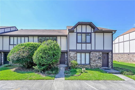 Front view of a two-story house with a brick and panel exterior.
